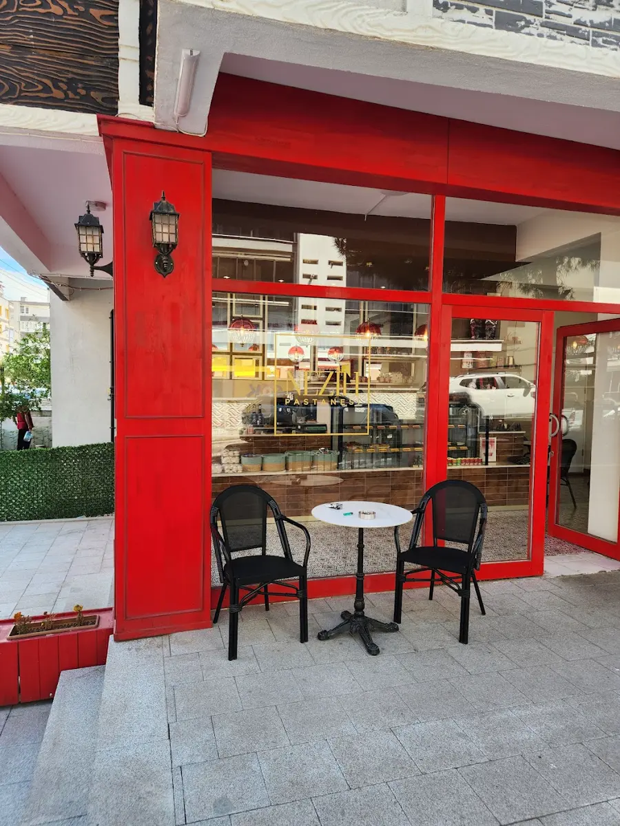 Kırmızı çerçeveli dükkân önü ve dış masalar